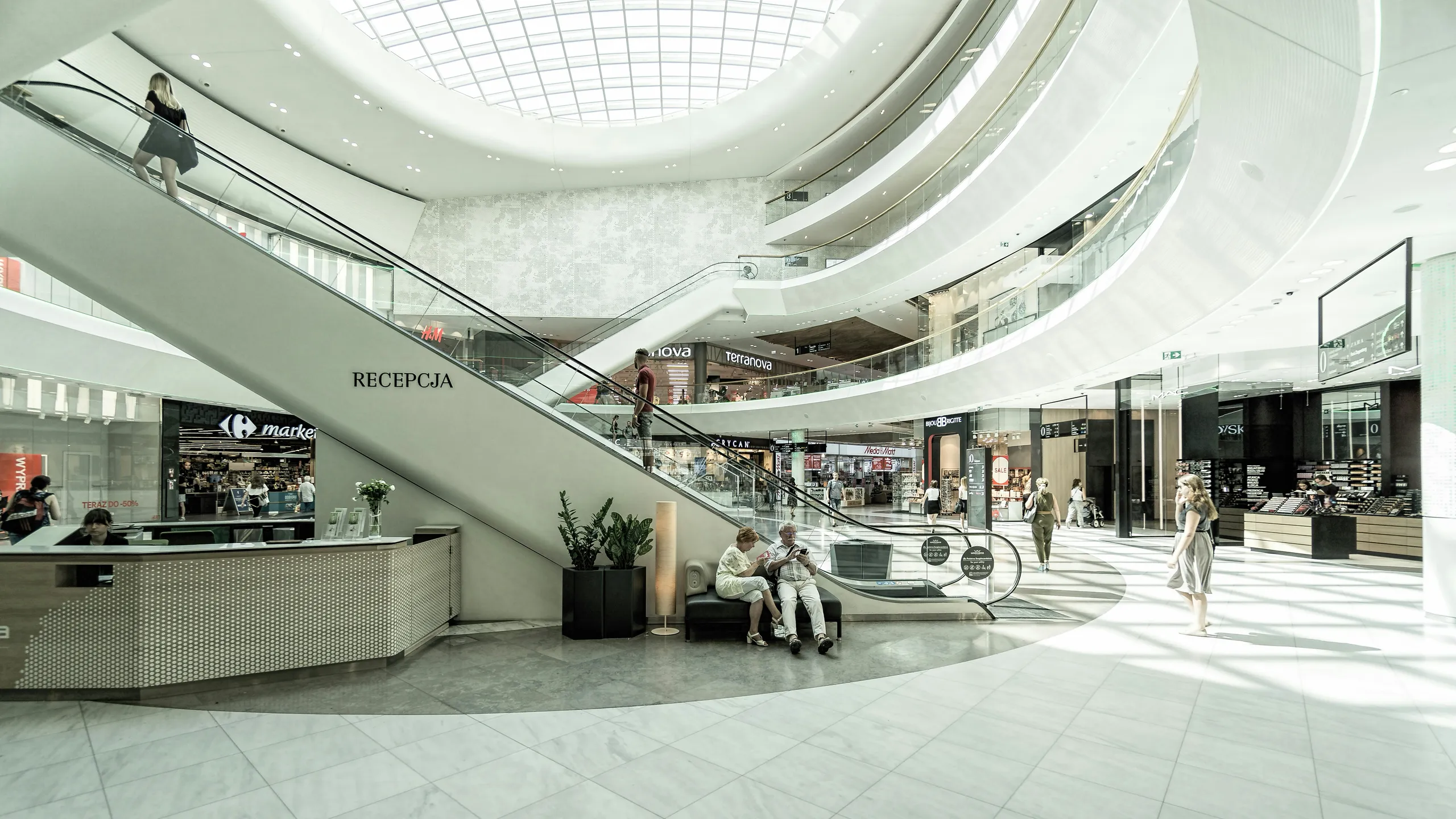 Interior luminoso de una nave amplia con galerías y escaleras mecánicas